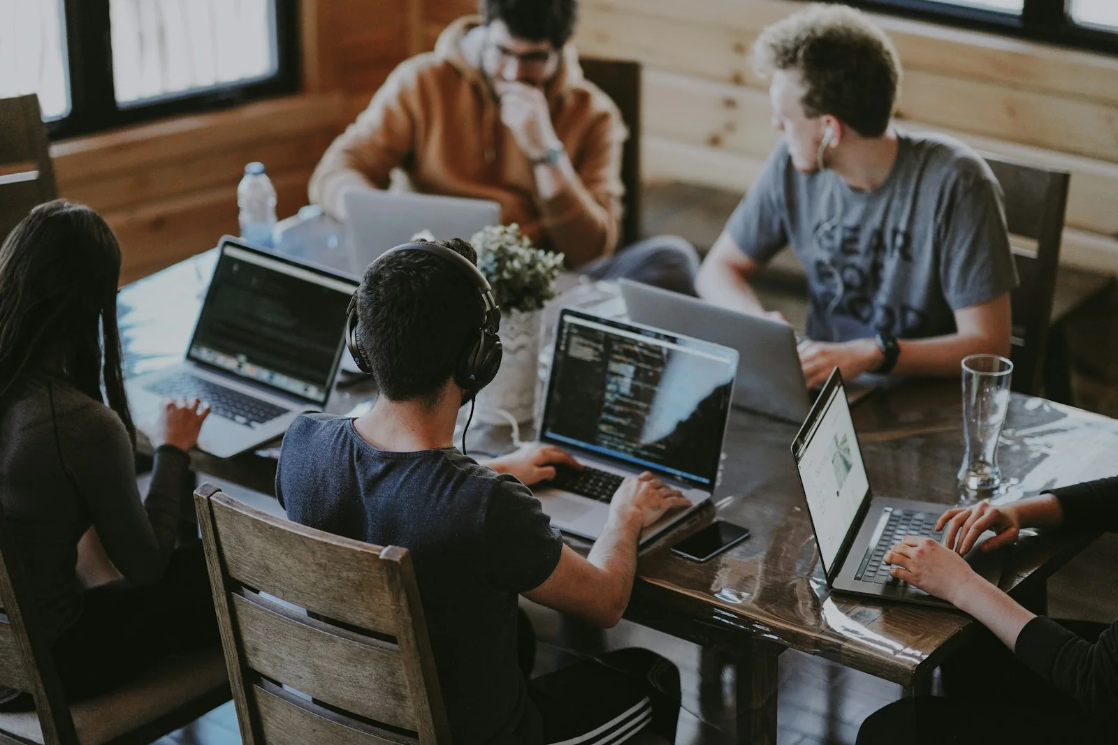 People collaborating around a table with laptops